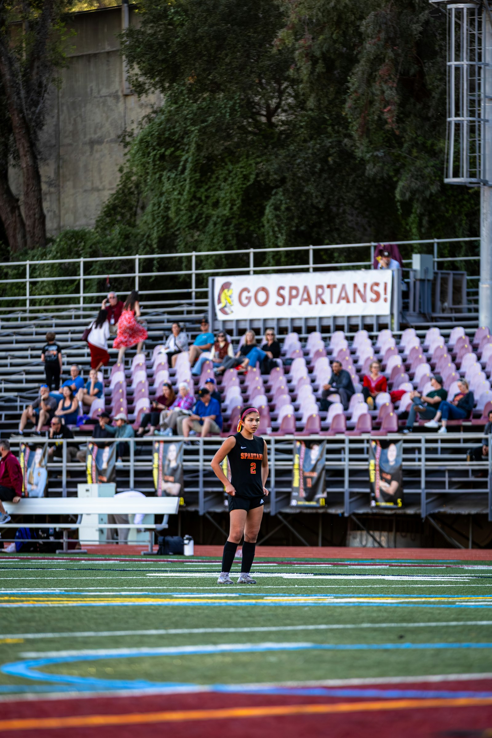 Jeune joueuse devant les tribunes où les parents suivent le match