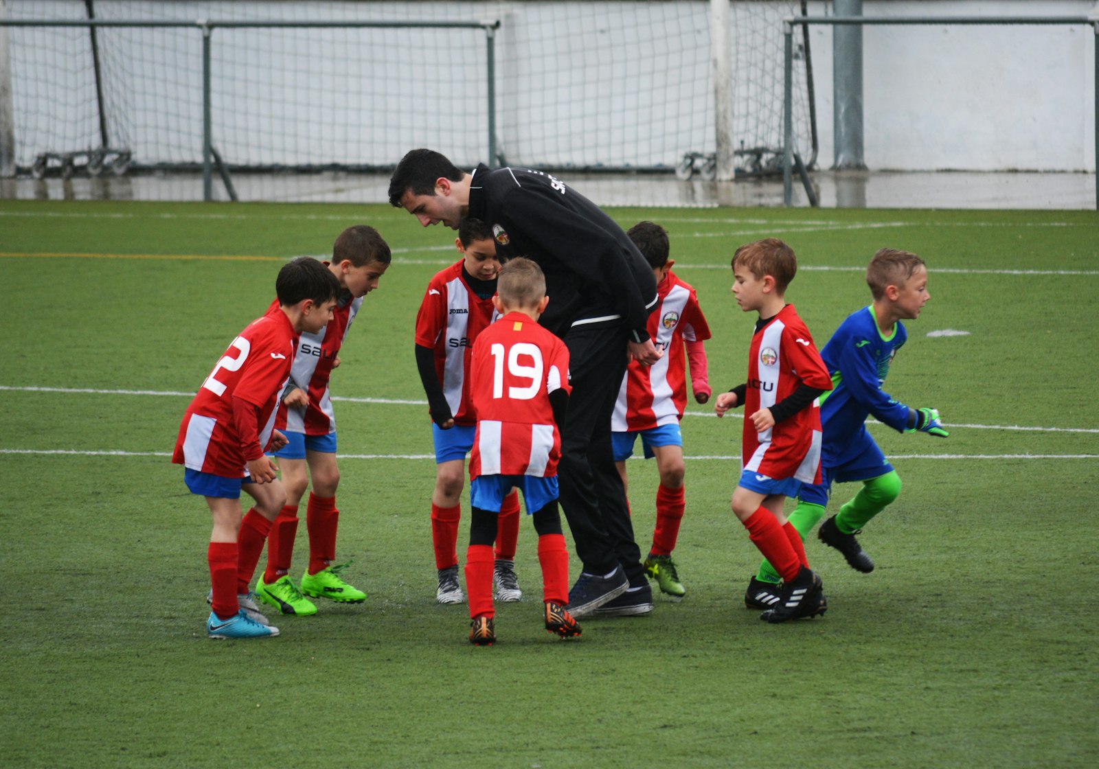 Jeunes d’un club autour de leur coach après un match